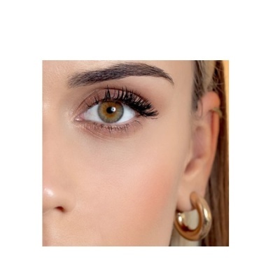 Metade do rosto feminino com brinco de argola dourada.