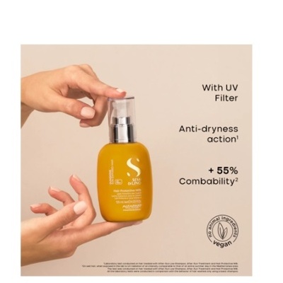 Frasco amarelo de produto cosmético com tampa transparente e selo vegan, mãos segurando contra fundo bege