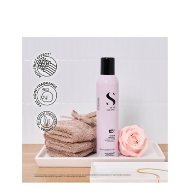 Frasco de spray cosmético rosa, toalhas castanhas e rosa cor de rosa em bandeja branca.