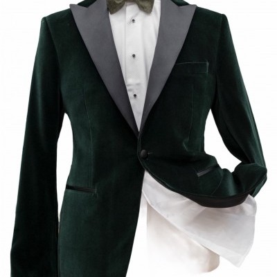 Blazer verde escuro de veludo com lapela preta, camisa branca e gravata borboleta verde.
