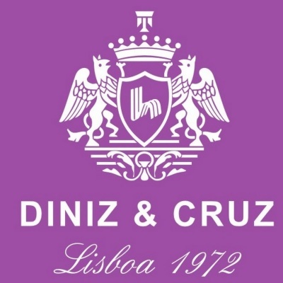 Logótipo branco com brasão e texto 'DINIZ & CRUZ Lisboa 1972' sobre fundo roxo