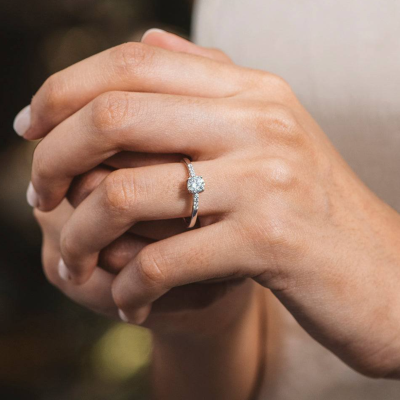 Mão feminina com anel de diamante em ouro branco