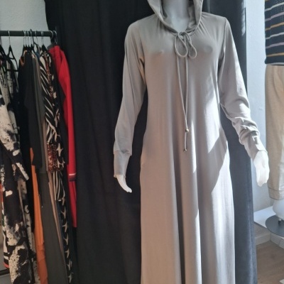 Vestido cinzento comprido com capuz e cordão em manequim branco