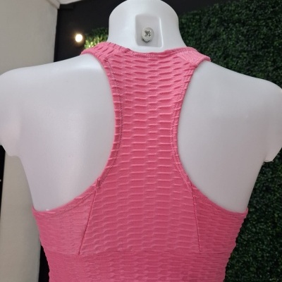 Top desportivo rosa texturizado visto de costas num manequim branco