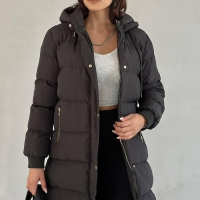 Mulher com casaco acolchoado preto e boné cinzento riscado