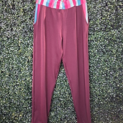 Calças vinho com cintura e punhos às riscas coloridas penduradas em cabide