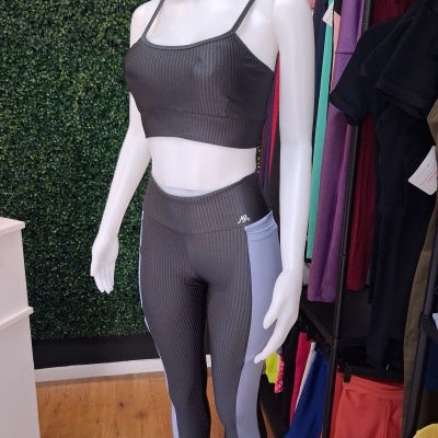 Conjunto desportivo cinza escuro com detalhes cinza claro em manequim de loja