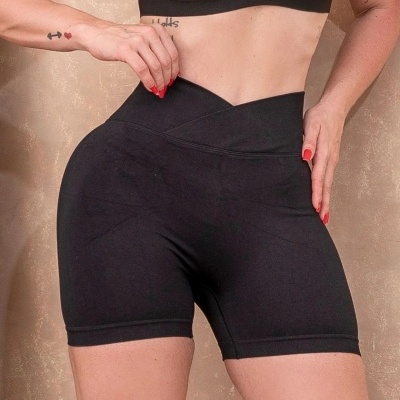 Calções de desporto pretos com cós alto cruzado em fundo bege texturado