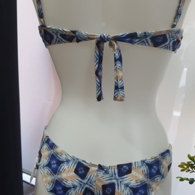 Biquíni estampado azul e bege num manequim branco vista de costas
