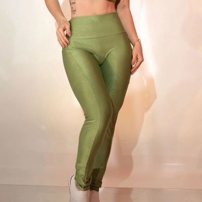 Conjunto desportivo verde claro com top e leggings justas e sapatilhas brancas.