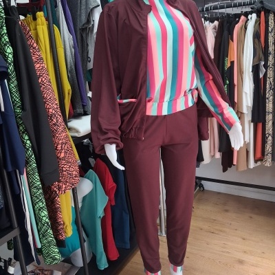 Fato de treino bordeaux com camisola às riscas verdes e rosas em manequim numa loja de roupa