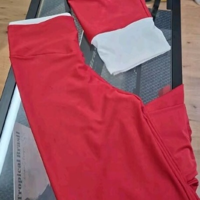 Conjunto desportivo vermelho e branco sobre mesa de vidro