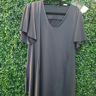 T-shirt preta de mangas curtas em fundo verde de folhagem