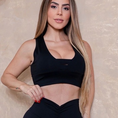 Mulher com top desportivo preto e leggings pretas ajustadas