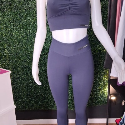Fato de treino feminino azul escuro com top cropped e leggings mostrados num manequim