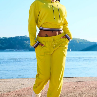 Mulher com roupa desportiva amarela junto a um rio