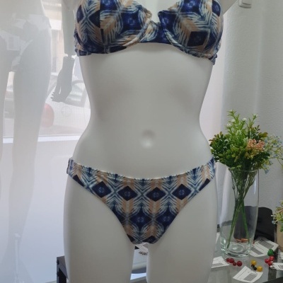 Fato de banho de duas peças com padrão azul, bege e branco em manequim branco