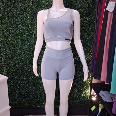 Conjunto desportivo cinzento claro em manequim com fundo verde