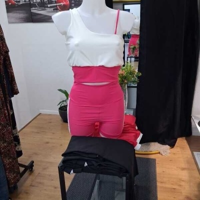 Mannequim com top branco e calções cor-de-rosa numa loja de roupas
