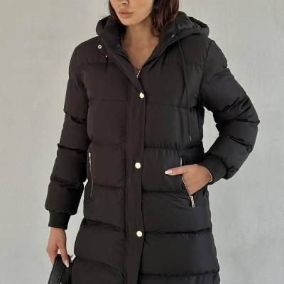 Mulher veste casaco acolchoado preto comprido com capuz e fecho, e boné cinzento riscado