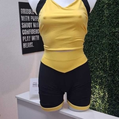 Conjunto desportivo feminino amarelo e preto em manequim