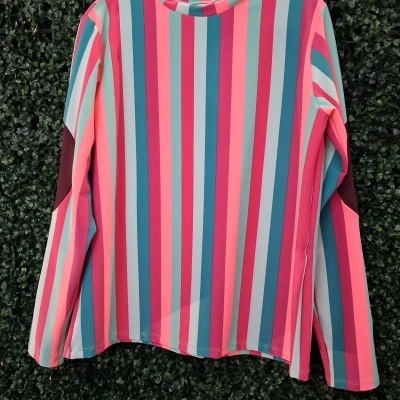 Camisola de riscas verticais coloridas pendurada em cabide
