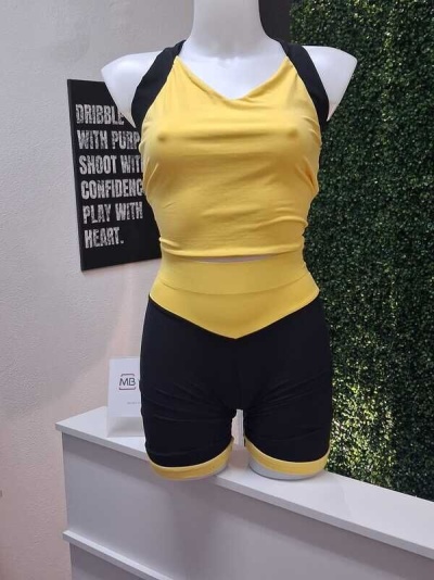 Conjunto desportivo feminino amarelo e preto em manequim