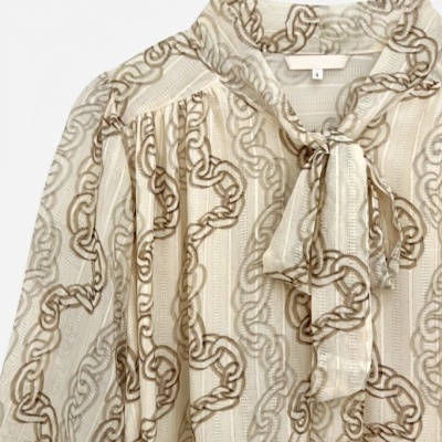 Blusa leve com padrão de correntes e laço frontal