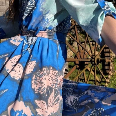 Vestido floral azul com rosa e branco, mangas compridas e faixa na cintura