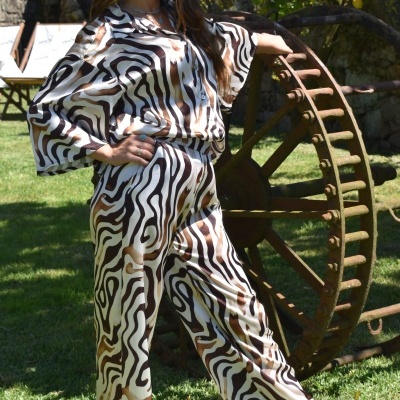 Macacão comprido padrão animal castanho e branco ao ar livre com roda de madeira