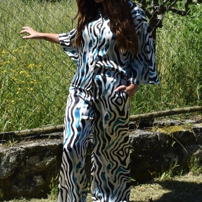 Macacão comprido com padrão abstrato azul, preto e branco em ambiente exterior