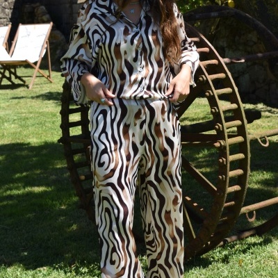 Conjunto de pijama com padrão animal bege, castanho e preto num jardim