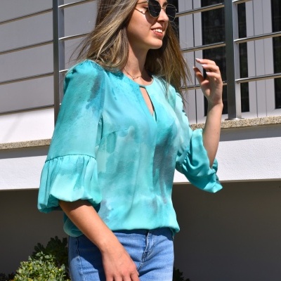 Blusa azul claro de manga 3/4 bufante em cenário exterior