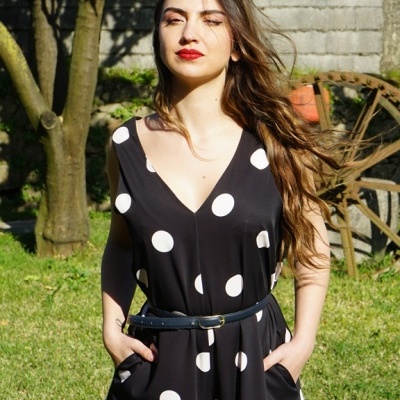 Macacão preto com bolinhas brancas usado por mulher ao ar livre