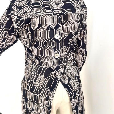 casaco comprido com padrão geométrico preto e branco visto de costas