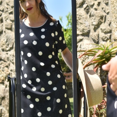 Vestido preto com bolinhas brancas visto em espelho ao ar livre