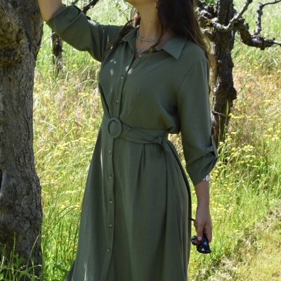 Vestido comprido verde oliva com botões frontais e cinto largo usado ao ar livre