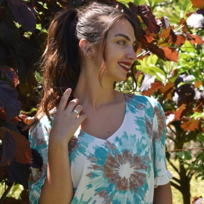 Mulher com vestido branco com estampado floral azul e castanho ao ar livre