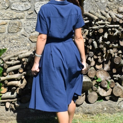 Vestido azul médio com manga curta e cintura marcada visto pelas costas