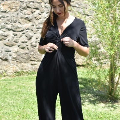 Mulher a usar macacão preto de manga curta com nó frontal num jardim