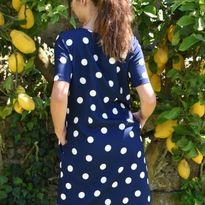 Vestido azul escuro com bolinhas brancas usado ao ar livre