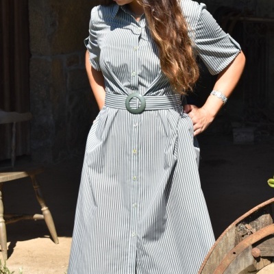 Vestido midi de riscas finas com botões e cinto largo numa mulher