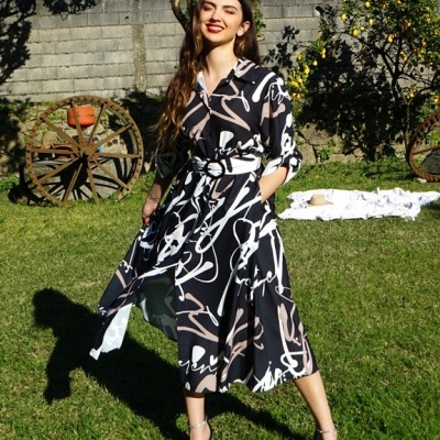 Mulher a usar vestido midi estampado preto, branco e bege no jardim