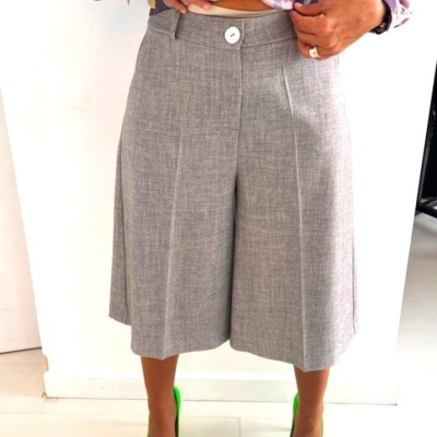 Calças compridas culottes cinza claro com sapatos verdes fluorescentes e camisa floral