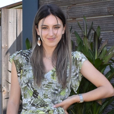 Mulher com vestido floral verde posando ao ar livre