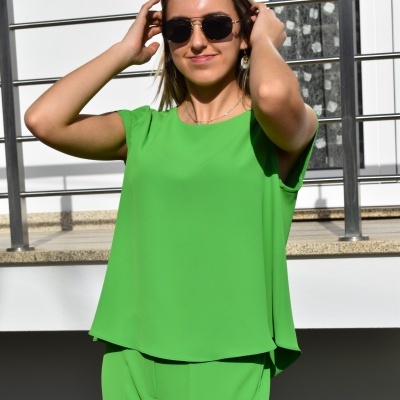 Mulher com conjunto verde e óculos de sol