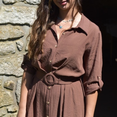 Mulher a usar vestido camisa castanho com botões e cinto em tecido leve