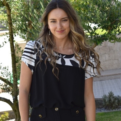 Mulher com vestido preto e camiseta padrão floral preto e branco ao ar livre