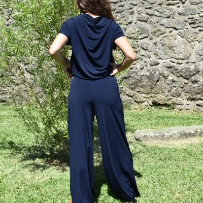 Macacão azul escuro de mangas curtas e pernas largas visto de costas