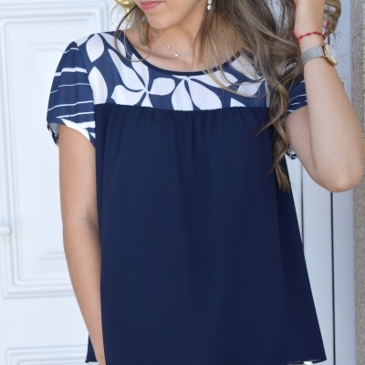 Blusa azul escuro com estampa branca de folhas e calças brancas